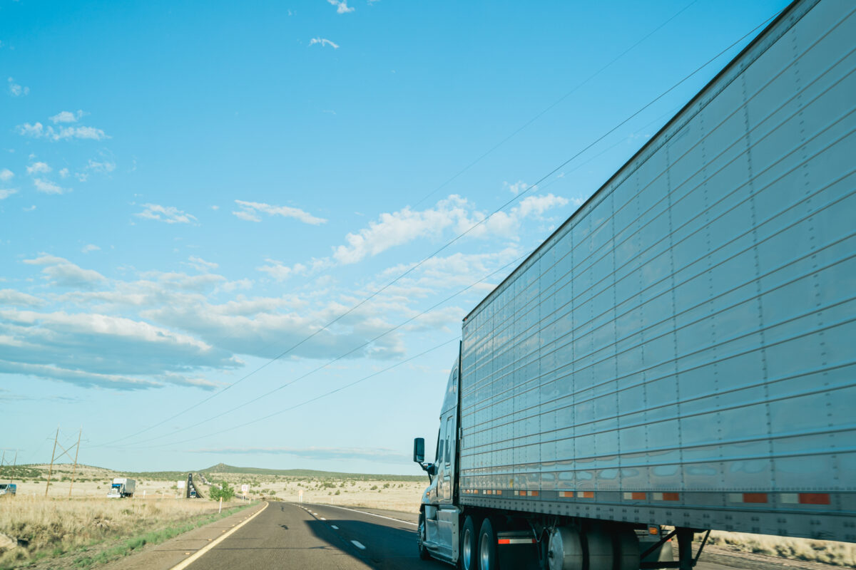 side-view-driving-almost-parallel-freight-truck-road-summer-road-trip-overtaken-by-big-trailer-2-1200x800.jpg